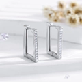 Macro view of rectangular silver hoop earrings featuring fine rows of pavé set white zircons - Silver (EH549)