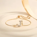 Detail of adjustable gold-plated bracelet with Zircon-inlaid letter J on a minimalist base - Letter J