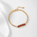Detailed close-up of 14K gold plated bracelet with amber stones and heart tag - Gold Chain Red