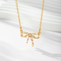 Detailed view of a gold-plated bow necklace pendant with inlaid rectangular cubic zirconia - Gold / White Zirconia