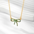 Vue détaillée du collier avec pendentif nœud doré et pierres de zircon vert émeraude - Or / Zircone Vert