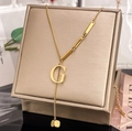 Macro detail of gold letter G pendant with S.STEEL hallmark on polished fringe chain - Letter G