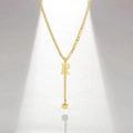 Detail of gold letter R pendant necklace with asymmetric chain and cube tassel - Letter R