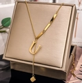 Macro detail of a gold U-letter pendant necklace with rectangular accents and a cube charm - Letter U