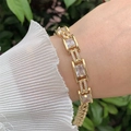 Detail van een 18k vergulde armband met emerald geslepen zirkoon om de pols van model - Rechthoekige Transparante Steen Stijl (2)
