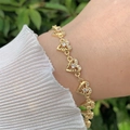 Elegantes 18K vergoldetes Herzarmband mit Zirkonia-Steinen an weiblichem Handgelenk - Hohlherz-Stil (5922727068518)