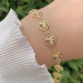 Elegantes 18K vergoldetes Herzarmband mit Zirkon-Steinen am Handgelenk bei sanftem Licht - Reihenzirkonia-Herz-Stil (5922727068519)