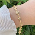 Primer plano de la pulsera de flores bañada en oro de 18K con circonitas en la muñeca - Estilo Flor de Cinco Pétalos (2)