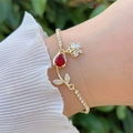 Detail van een 18K gouden armband met rode zirkoon en tulpvormig bloemmotief - Helderrode Hoofdsteen Bloem Stijl (3)