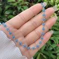 Dettaglio del bracciale Evil Eye placcato oro 18K con perline blu sul polso - Collana / Blu