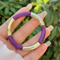Detail of purple and gold beaded stretch bracelet on wrist with outdoor background - Purple and Gold (1)