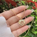 Detail of 18K gold heart pendant necklace with zircon Q letter in outdoor light - 18K Gold / Gold Q