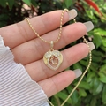 Detail showing hand holding 18K gold plated heart pendant with zircon and floating letter U - 18K Gold / Gold U