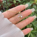 Nahaufnahme der 18K vergoldeten Blumenhalskette mit Zirkonia in der Hand gehalten - Einfacher Zirkonia-Blumenstil (SGXL007-3)