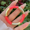 Detail of neon pink resin and gold curved tube stretch bracelet on a female wrist - Neon Pink Marble Gold Style (1)
