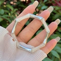 Detailopname van de crème hars en zilveren bamboe-elementen op de stijlvolle armband - Off-white (Zilveren Knoop)