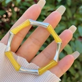 Detailopname van een bamboe-armband met barnsteenkleurige harssegmenten en zilver metaal - Heldergeel (Zilveren Knoop)
