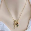 Dettaglio della collana a sfere placcata oro 18K con ciondoli cuore, croce e rosa su camicia - Cuore Con Lettera Cava E Ciondolo Croce Rosa / Oro 18K / Oro