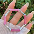 Bracciale in resina a bambù rosa e argento tenuto in mano con sfondo naturale esterno - Rosa (Giunto Argento)