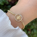 Close-up of golden beaded bracelet with San Benito medal and sparkling zircon frame - Round Saint Benedict (3)