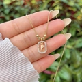 Macro detail of 18K gold plated letter P pendant with sparkling cubic zirconia inlay - Gold P