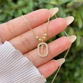 Macro detail of gold-plated letter T pendant with pavé cubic zirconia on box chain - Gold T