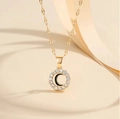 Macro shot of gold pendant with circular zircon pave and black crescent moon detail - Letter C