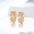 Close-up of gold-plated hoop earrings with small zircons and elegant white round pearls - Triple Row Micro-Inlay (EH882)