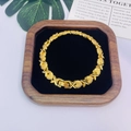 Détail d'un bracelet doré avec maillons cœur et fleur sur un plateau en velours - Maillon Coeur Fleur à Quatre Feuilles (PSL179)