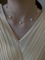 Close-up of elegant pearl and gold bead necklace worn by a model in a V-neck shirt - Gold Yellow