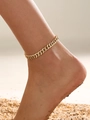 Close-up of golden stainless steel curb chain anklet worn on person at beach - Curb Chain / Gold Yellow
