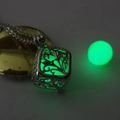 Close-up of a hollow tree of life cube pendant with green glowing luminous bead - Luminous Green