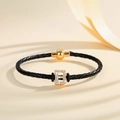 Close-up of black braided leather bracelet with golden diamond-studded B letter pendant - Letter B (PSL221--B)