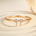 Minimalist gold plated bow bracelet with micro-paved diamonds on elegant silk background - Gold