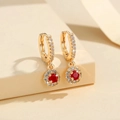 Detailopname van vergulde druppeloorbellen met rode ronde kristal en zirkonia accenten - Rood (PEH175)