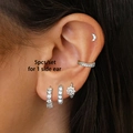 Macro detail of a 5-piece silver-tone zircon ear cuff set worn on a female ear - 24K / Silver