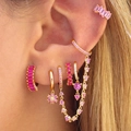 Luxe vergulde oorbellen set met sprankelende roze zirkonia stenen op het oor van het model - 24K / Goud-Roze Zirconia