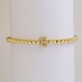 Gedetailleerde macro van gouden kralenarmband met fonkelende zirkonia letter E sieraad - Letter E