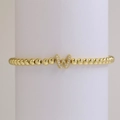Macro-opname van gouden kralenarmband met fonkelende zirkonia-ingelegde letter W-hanger - Letter W