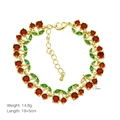 Detail view of gold cherry bracelet with red crystal fruits and green leaf charms - Red Gemstone Cherry Style (DB250503-B)