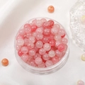 Pink and white ice-cracked glass beads in a clear storage box for DIY jewelry - Pink