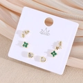 Nahaufnahme des 6er-Ohrring-Sets mit goldenem Stern, Herz und grüner Blume auf Satin - Herz & Grüner Klee Stil (EP01-1)