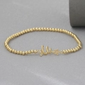 Close-up of 18k gold-plated beaded bracelet with star pendant and inlaid crystals - Christmas Tree Star Style (NAG10-7)