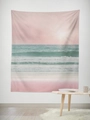 Detailed close-up of a pink sunset beach tapestry hanging on a white wall in a room - 95x73 / Brushed Fabric