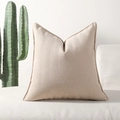 Moderne crème chenille kussenhoes met visgraattextuur op een witte bank met cactus - Melkthee Kleur