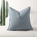 Grijsblauwe chenille kussenhoes met visgraatpatroon op een witte bank - Mistblauw