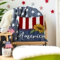 Detail of sunflower and America text on flag-themed cushion cover on a wicker chair - 28
