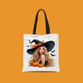 Close-up of a white Halloween canvas tote bag with a colorful witch and pumpkin print - Blonde Witch Hat Lady Style (FBDT02-13)