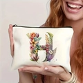 Close-up of white canvas makeup bag featuring a floral letter H design held by a model - Letter H (TSND27-8) / 21.5x15cm