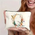 White canvas makeup bag with floral letter Q print held by a model with zipper closure - Letter Q (TSND27-17) / 21.5x15cm